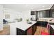 Bright kitchen features an island with quartz countertop, stainless steel appliances and dark cabinetry at 6844 Bayou Hollow Ave, Las Vegas, NV 89156