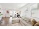 Open-concept living room featuring wood floors, a comfortable sectional, and sliding glass doors to the backyard at 6844 Bayou Hollow Ave, Las Vegas, NV 89156