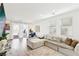 Bright living room with a plush sectional sofa, wood floors, and sliding glass doors leading to the backyard at 6844 Bayou Hollow Ave, Las Vegas, NV 89156