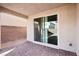 A close up of the covered patio with brick base with the yard beyond and sliding door entry at 6844 Bayou Hollow Ave, Las Vegas, NV 89156