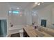 Bright bathroom featuring a tub, shower, and a sleek vanity with a modern sink and faucet at 8144 Monsoon Bay St, Las Vegas, NV 89113