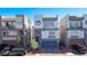Modern home with a three-story layout, stylish gray and white exterior, brick driveway, and a two car garage at 8144 Monsoon Bay St, Las Vegas, NV 89113