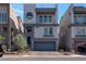 Modern three-story home with a gray exterior, two-car garage, and manicured front yard at 8144 Monsoon Bay St, Las Vegas, NV 89113