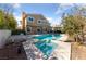 Back exterior view of home featuring a pool, spa, manicured landscaping, and neutral paint at 8904 Saint Pierre Dr, Las Vegas, NV 89134
