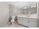 Bright bathroom features a vanity with white cabinets, tile floor, and a large mirror at 8904 Saint Pierre Dr, Las Vegas, NV 89134