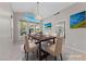 Elegant dining room featuring a chandelier, large windows and a dining table with seating for six at 8904 Saint Pierre Dr, Las Vegas, NV 89134