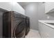 Efficient laundry room featuring modern washer and dryer and ample storage space with white cabinets at 8904 Saint Pierre Dr, Las Vegas, NV 89134