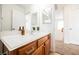A bright bathroom featuring wood cabinetry and a large mirror above the vanity at 9257 Harbor Stream Ave, Las Vegas, NV 89149