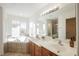 Spacious bathroom features double sinks, a large soaking tub, and bright natural light at 9257 Harbor Stream Ave, Las Vegas, NV 89149