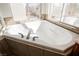 Corner bathtub with tile surround and natural light at 9257 Harbor Stream Ave, Las Vegas, NV 89149