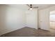 A carpeted bedroom with a closet, ceiling fan, and adjacent doorway to another room at 9257 Harbor Stream Ave, Las Vegas, NV 89149
