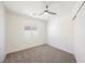 A carpeted bedroom features a window, neutral walls, and a ceiling fan at 9257 Harbor Stream Ave, Las Vegas, NV 89149