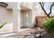 Home's entryway with decorative gravel and a detailed glass front door at 9257 Harbor Stream Ave, Las Vegas, NV 89149