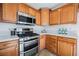Well-equipped kitchen features stainless steel appliances, wooden cabinets, and quartz countertops at 9257 Harbor Stream Ave, Las Vegas, NV 89149