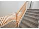 Carpeted staircase with wood railing leads to the upper level of the home at 9257 Harbor Stream Ave, Las Vegas, NV 89149
