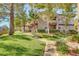 Exterior of condo building with lush green lawn and mature trees at 5250 S Rainbow Blvd # 1165, Las Vegas, NV 89118