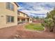 This backyard has gravel, a patch of green grass, and a dining area outside the home's rear windows at 1009 Rustridge Ave, North Las Vegas, NV 89081