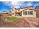 A backyard featuring a green grass area and gravel surroundings, accompanied by an outdoor dining space at 1009 Rustridge Ave, North Las Vegas, NV 89081