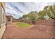 The backyard features a green grass area surrounded by decorative gravel, along with trees and a brick wall at 1009 Rustridge Ave, North Las Vegas, NV 89081