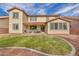 An expansive backyard showcasing a lush green lawn, complemented by a stone patio and a cozy dining set at 1009 Rustridge Ave, North Las Vegas, NV 89081