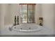 Luxurious bathroom with a jetted tub, tiled surround, and elegant fixtures at 1009 Rustridge Ave, North Las Vegas, NV 89081