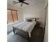 Cozy bedroom features a comfortable bed, ceiling fan, and natural light from the window at 1009 Rustridge Ave, North Las Vegas, NV 89081