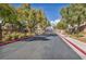 Gated community entrance showcasing lush landscaping with mature trees and well-maintained sidewalks at 1009 Rustridge Ave, North Las Vegas, NV 89081