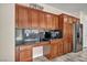 Cherry wood cabinets with black countertops and stainless steel refrigerator at 1009 Rustridge Ave, North Las Vegas, NV 89081