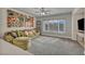 Cozy living room with large windows providing natural light and a comfortable seating area at 1009 Rustridge Ave, North Las Vegas, NV 89081