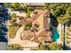 Aerial shot of a large luxury home with a tile roof, a sparkling pool, mature landscaping, and circular driveway at 12 Innisbrook Ave, Las Vegas, NV 89113