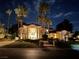 Elegant home at night featuring stately columns, palm trees, and professional landscaping at 12 Innisbrook Ave, Las Vegas, NV 89113