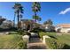 Elegant home featuring stately columns, palm trees, manicured landscaping, and walkway at 12 Innisbrook Ave, Las Vegas, NV 89113