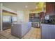 Modern kitchen with a stainless steel refrigerator, granite countertops, and ample cabinet space at 12 Innisbrook Ave, Las Vegas, NV 89113
