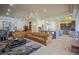 Open-concept living room with tile flooring, a large sectional, and a kitchen bar with granite countertops at 12 Innisbrook Ave, Las Vegas, NV 89113