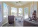 Charming sun room with multiple windows, cozy seating, and scenic views at 12 Innisbrook Ave, Las Vegas, NV 89113