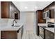 Galley kitchen with stainless steel appliances, dark cabinets, white countertops, and undermount sink at 1500 Saylor Way, Las Vegas, NV 89108