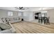Open-concept living area with hardwood floors, a gray sectional sofa, and views into the dining area and kitchen at 1500 Saylor Way, Las Vegas, NV 89108
