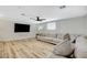 Spacious living room with wood floors, a large sectional sofa, mounted TV, and a ceiling fan at 1500 Saylor Way, Las Vegas, NV 89108