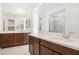 Bathroom featuring double sinks, quartz countertops, dark wood cabinets, and large mirror at 2255 Woodbluff Ave, North Las Vegas, NV 89086