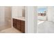 Bathroom featuring a glass walk-in shower and a vanity with quartz countertop and dark wood cabinets at 2255 Woodbluff Ave, North Las Vegas, NV 89086