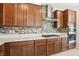 Modern kitchen featuring wood cabinets, mosaic backsplash, stainless steel hood, gas cooktop, and white countertop at 2255 Woodbluff Ave, North Las Vegas, NV 89086