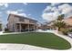 A sprawling backyard with lush turf, extended patio, and a built-in pool with grotto for Gathering gatherings at 23 Crescent Palm Ct, Henderson, NV 89002