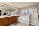 This bright bathroom offers a double sink vanity, soaking tub, and a separate shower stall at 23 Crescent Palm Ct, Henderson, NV 89002