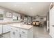 Bright kitchen with white cabinets, island, and eat-in dining area with updated light gray wood-look flooring at 23 Crescent Palm Ct, Henderson, NV 89002