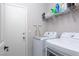 Functional laundry area with front load washer/dryer set and shelving for storage at 23 Crescent Palm Ct, Henderson, NV 89002
