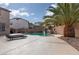 Relaxing backyard pool with a waterfall feature and lush palm trees creating a tranquil retreat at 23 Crescent Palm Ct, Henderson, NV 89002