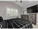 Modern bedroom featuring a gray color scheme, large window with shutters, and a TV on a wooden dresser at 2345 Cliffwood Dr, Henderson, NV 89074
