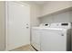 Convenient laundry room featuring modern washer and dryer, plus storage shelf at 2345 Cliffwood Dr, Henderson, NV 89074