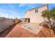 View of the spacious backyard with a concrete patio, small trees, and block wall at 2407 Belt Buckley Dr, Henderson, NV 89002