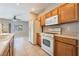 Traditional kitchen with wood cabinets and white appliances is open to the living area at 2407 Belt Buckley Dr, Henderson, NV 89002
